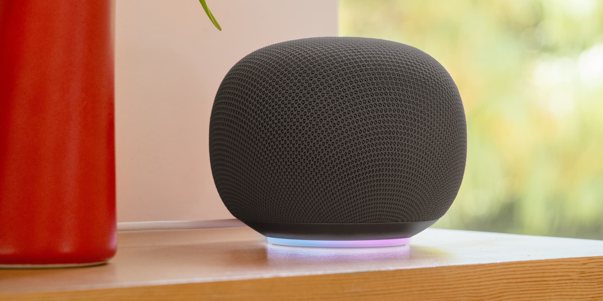 The new Google Home Speaker in Hazel with a fabric-wrapped cylindrical body and illuminated light ring