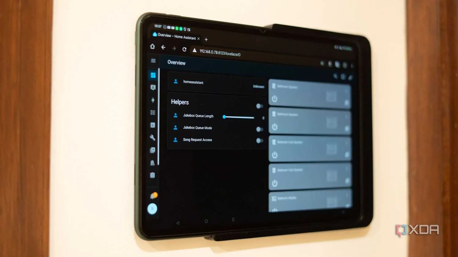 A wall-mounted tablet displaying a smart-home dashboard interface