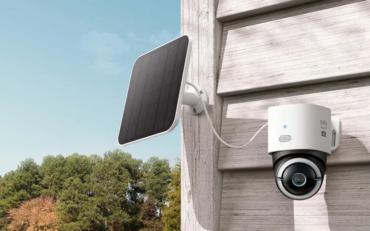 Battery-powered eufy security camera mounted on a wooden wall overlooking a rural property