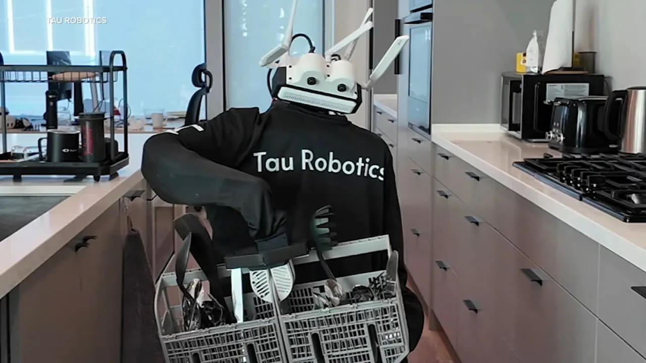 Tau Robotics humanoid robot standing in a residential interior during coverage of the San Francisco invite-only cleaning service