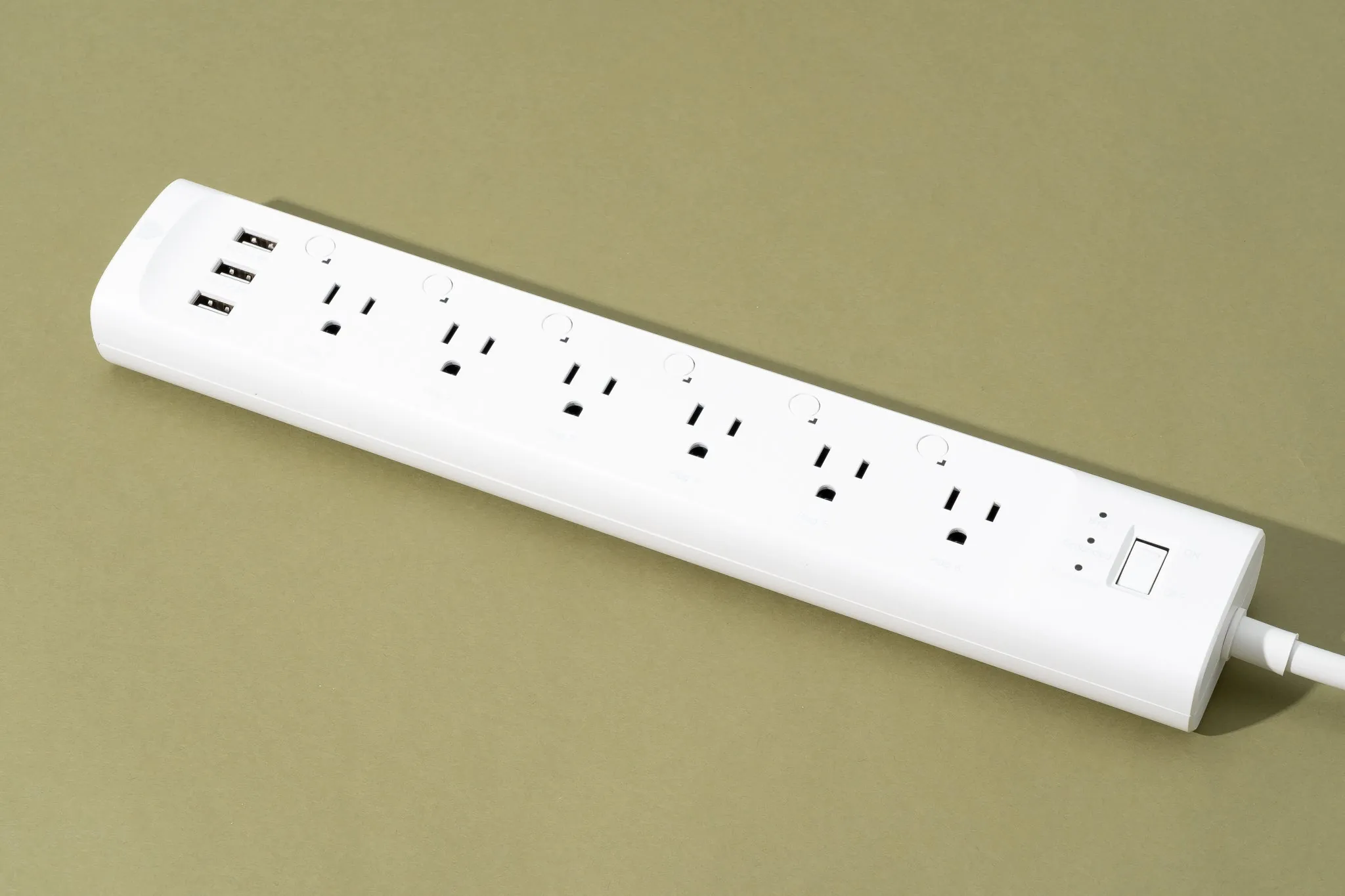 Smart plug in a wall outlet near household electronics