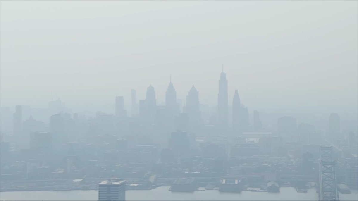 Hazy Philadelphia skyline under amber wildfire smoke during the July 17, 2026 Code Purple air quality alert