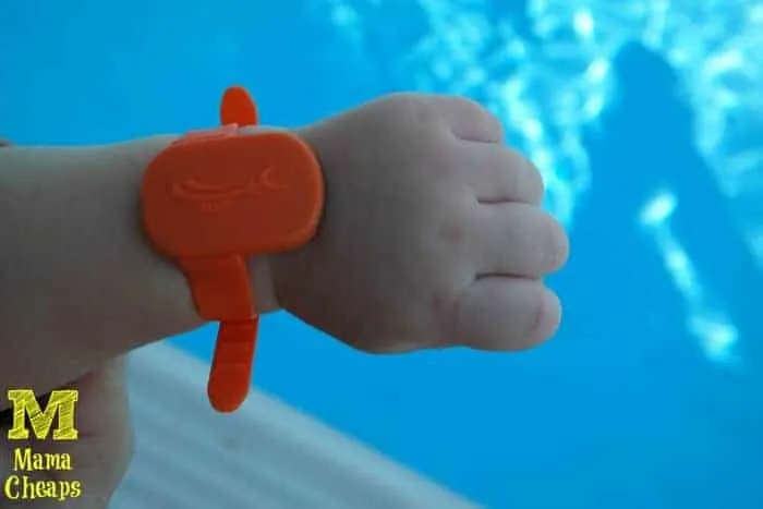 A child wearing the white iSwimband aquatic safety wearable on the wrist