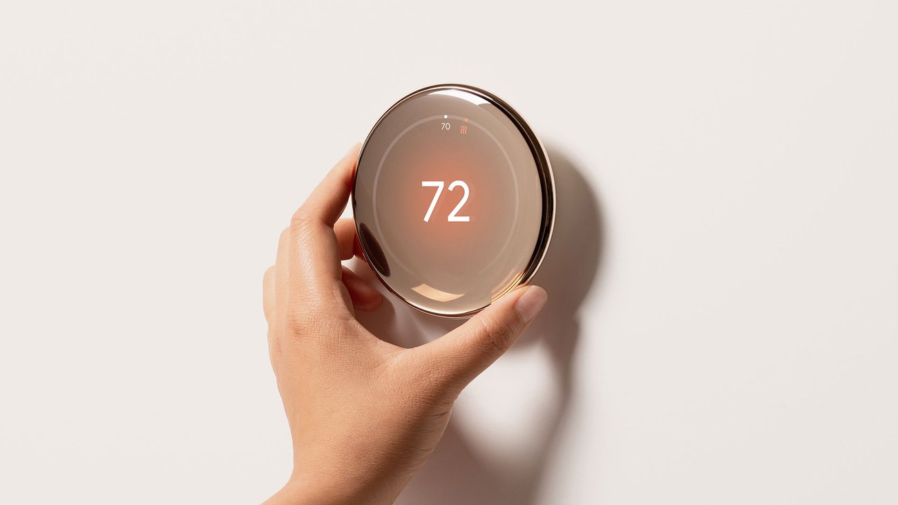 Google Nest Learning Thermostat 4th Gen on a clear stand with a circular reflective display