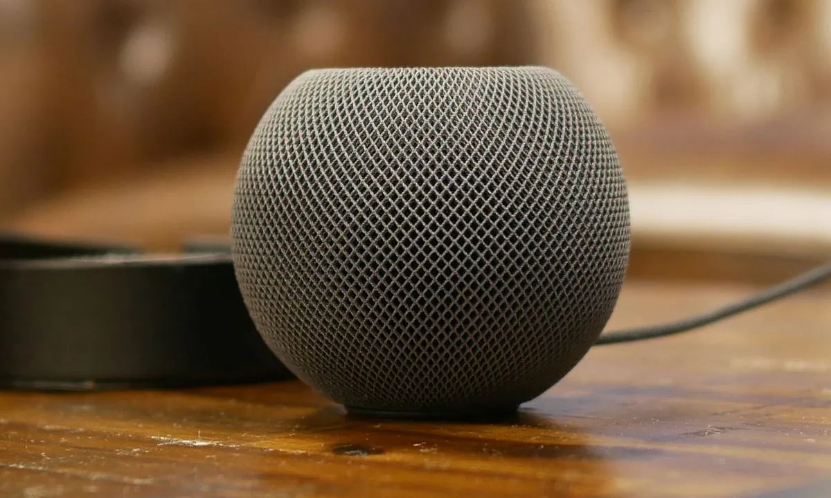 Apple HomePod mini sitting on a wooden side table